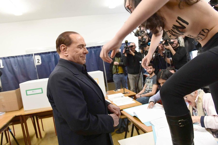 FOTO AFP-NA BERLUSCONI./ Ayer durante el momento de la votaci&oacute;n. RECHAZO./ Una mujer en topless: "Berlusconi has expirado".