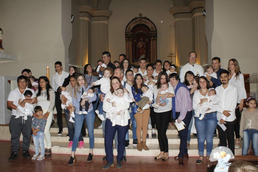 FOTO F. MELCHIORI// BAUTIZADOS./ El grupo que recibi&oacute; el sacramento del bautismo junto a sus padrinos y el padre Fernando Sepertino.
