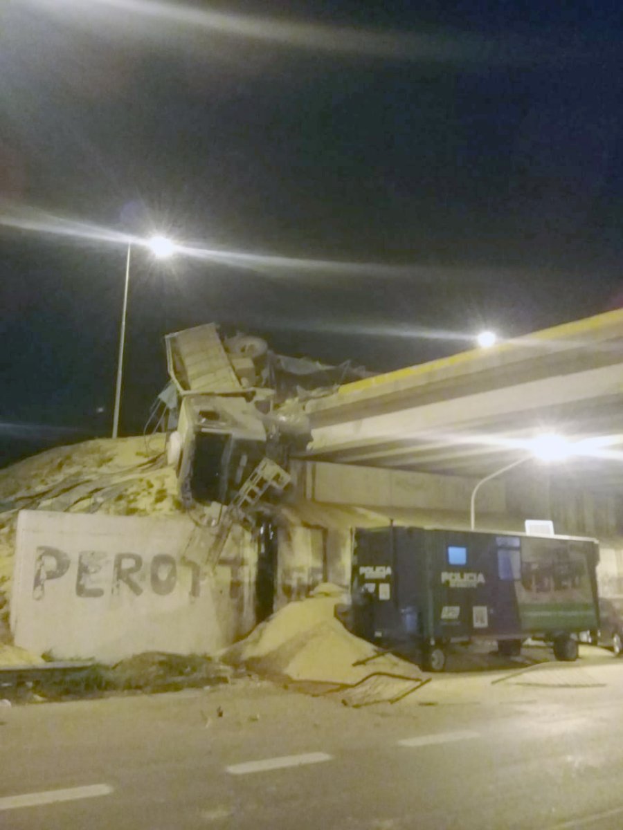 FOTO LA OPINION &ldquo;COLGADO&rdquo;. El cami&oacute;n Iveco con acoplado desparram&oacute; su carga de soja al caer desde el puente. S&oacute;lo hubo lesionados leves.