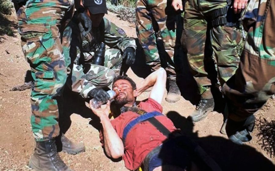FOTO NA DETENIDO. Cordi en el suelo, rodeado de polic&iacute;as, trata de beber agua.