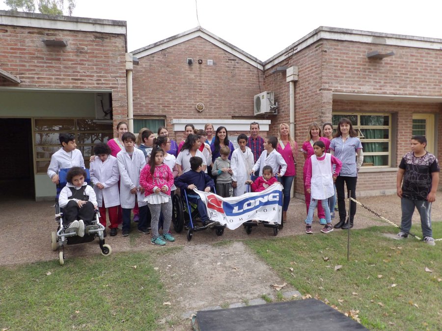 FOTO PRENSA LONG// ESCUELA./ Los integrantes de la comunidad educativa en el momento de recibir el aporte. DONATIVO./ Las dos sillas de ruedas aportadas por la empresa local.