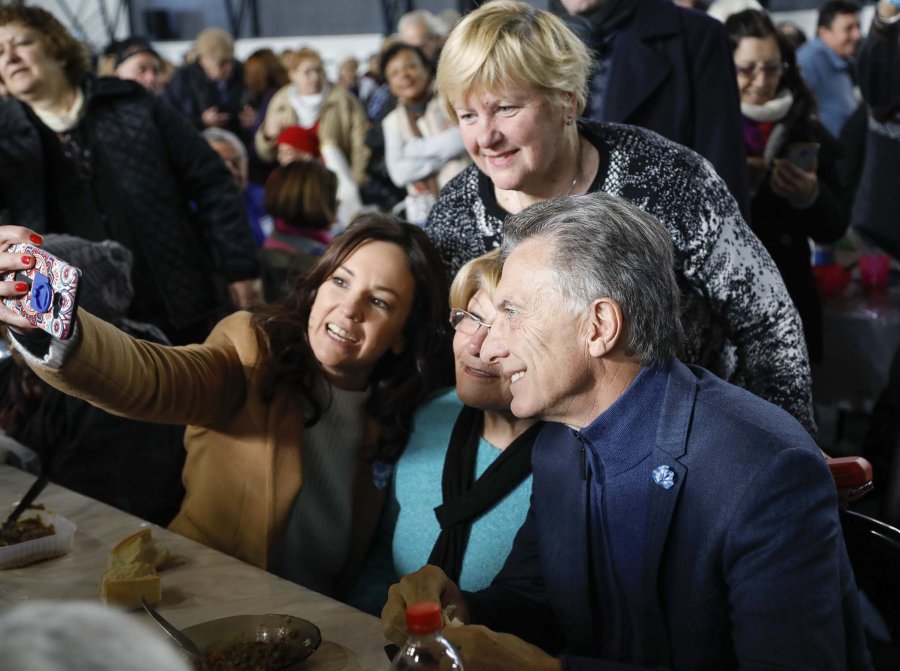 FOTO NA CANDIDATOS. Macri en una lentejeada con adultos mayores de Tres de Febrero; Fern&aacute;ndez junto a trabajadores en Mendoza.