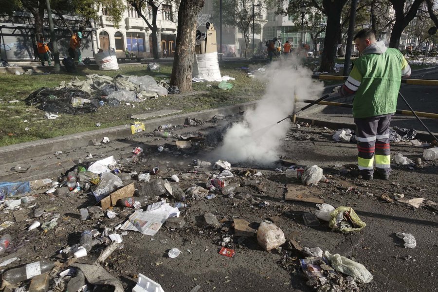 FOTO NA UN BASURAL. Personal de Gobierno porte&ntilde;o limpia el sector del acampe.