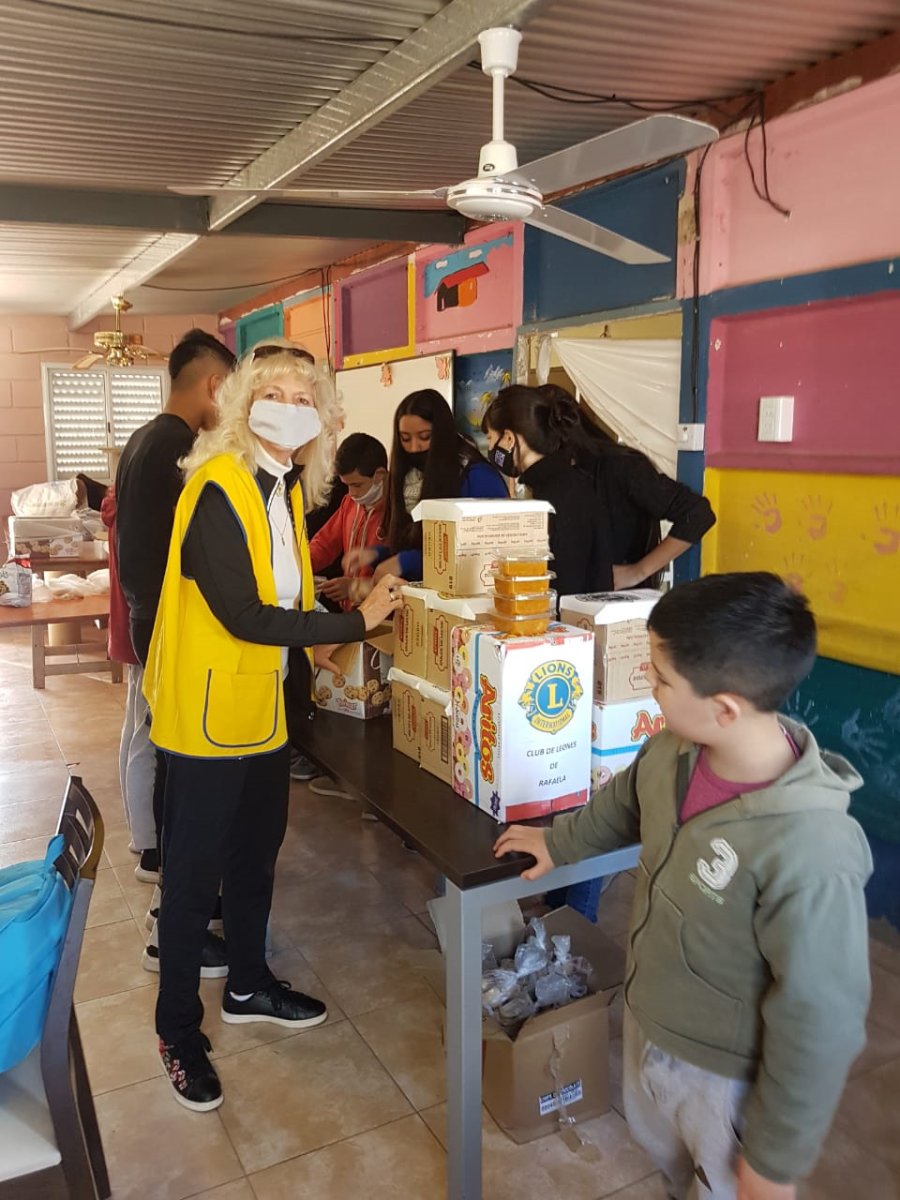 FOTO PRENSA LEONES// ENTREGA//  Lianan Friedrich efectivizando el aporte al merendero. GOLOSINAS// Fueron distribuidas durante el fin de semana largo.