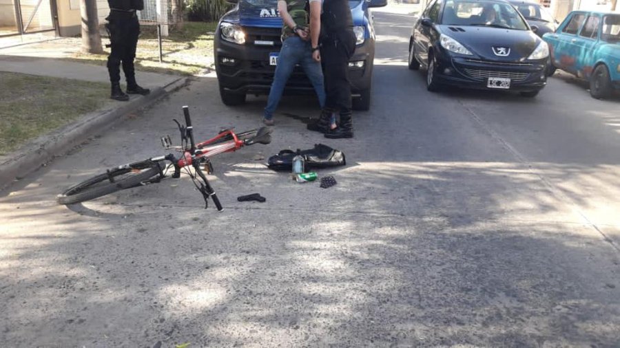FOTO LA OPINION ESCENARIO. La bicicleta junto al arma y el sujeto esposado por los polic&iacute;as.