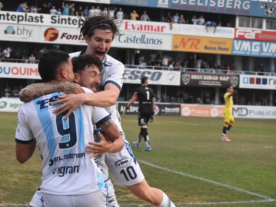 FESTEJO DE GOL. Tomatis en lo m&aacute;s alto y un abrazo interminable con Dichiara y Aguirre.
