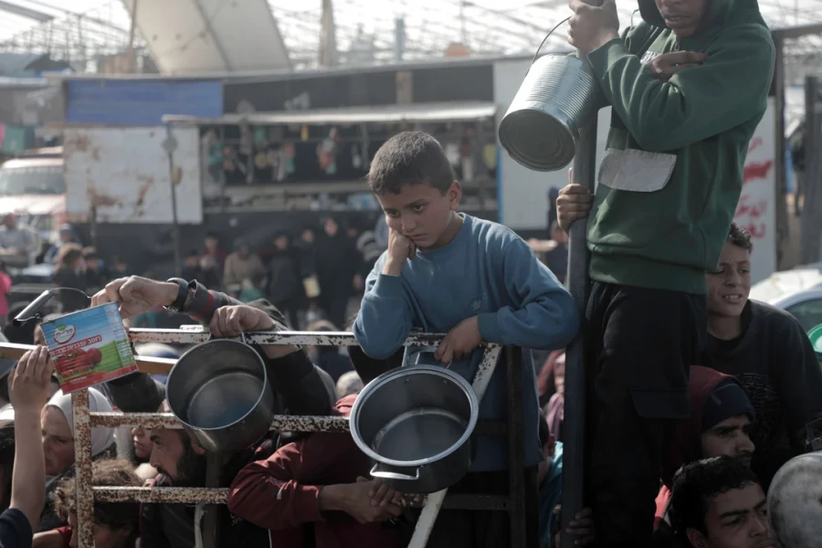 Palestinos esperan para recibir comida gratuita de un centro de distribuci&oacute;n de alimentos, en la ciudad de Khan Younis, tras iniciarse el Alto el Fuego.