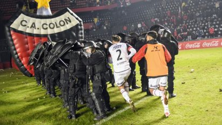 VIOLENCIA. Los jugadores locales debieron dejar la cancha protegidos por la polic&iacute;a.