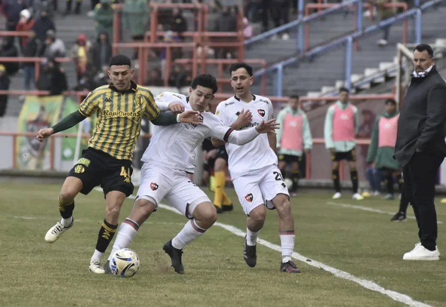 Giuliano Cerato disputa la pelota ante la marca del paraguayo Carlos Gonz&aacute;lez.
