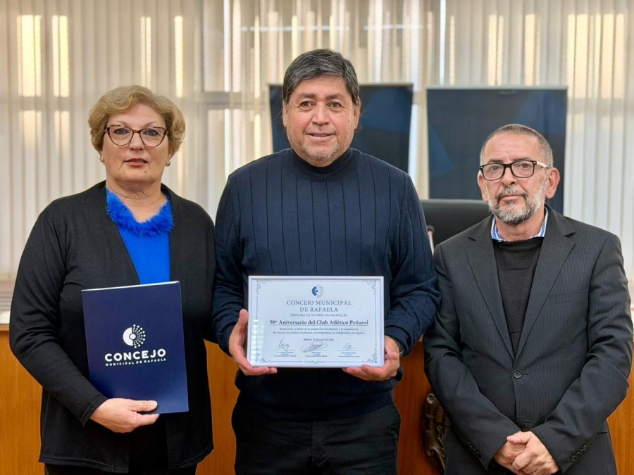Alejandro B&aacute;ez, presidente de Club Pe&ntilde;arol, recibe la declaratoria de Inter&eacute;s Municipal por el 90&deg; aniversario de la instituci&oacute;n de parte de los concejales Mabel Fossatti y Juan Scavino. (FOTO PRENSA CONCEJO)