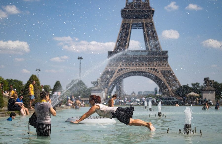TEMPERATURAS MAXIMAS HISTORICAS. Varias personas se refrescan en la Fuente del Trocadero, junto a la Torre Eiffel, mientras las temperaturas suben durante una ola de calor que afecta a Francia.