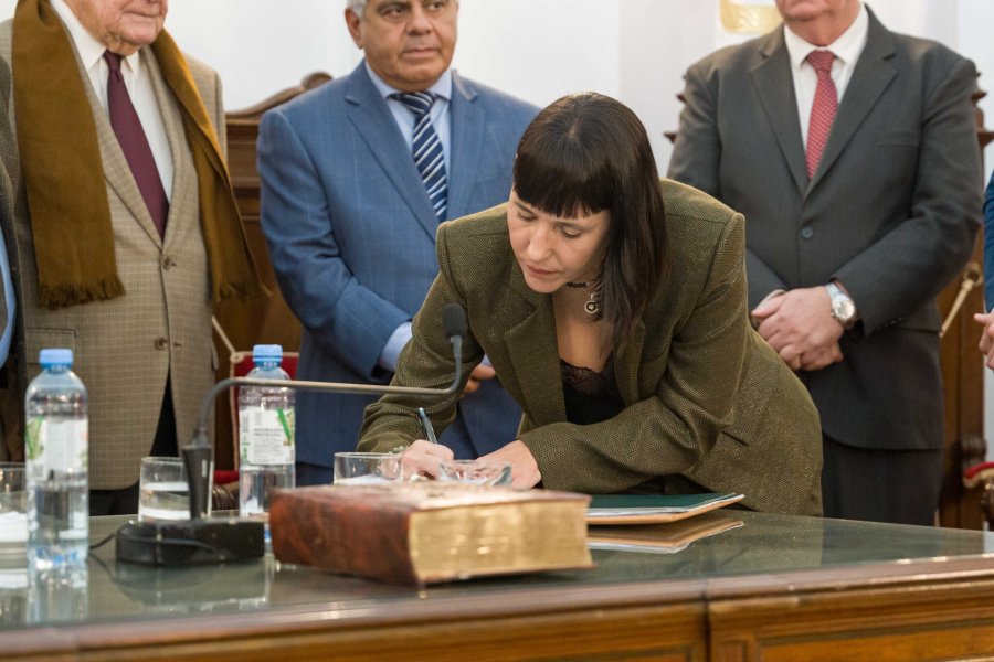 Tras prestar juramento, la Dra. Natalia Carinelli firma el acta correspondiente ante la mirada de los jueces de la Corte Suprema de Justicia de Santa Fe.